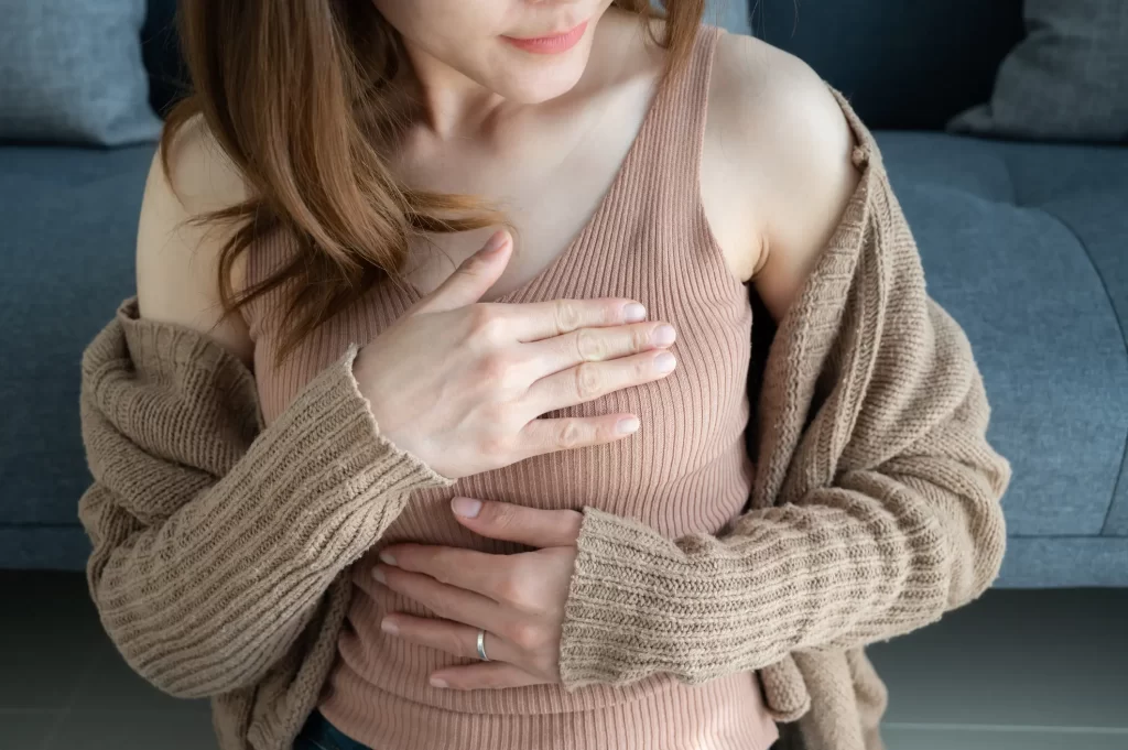 Woman with hand over breast