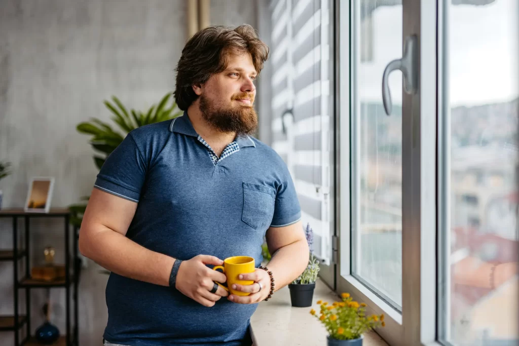 Man looking out window